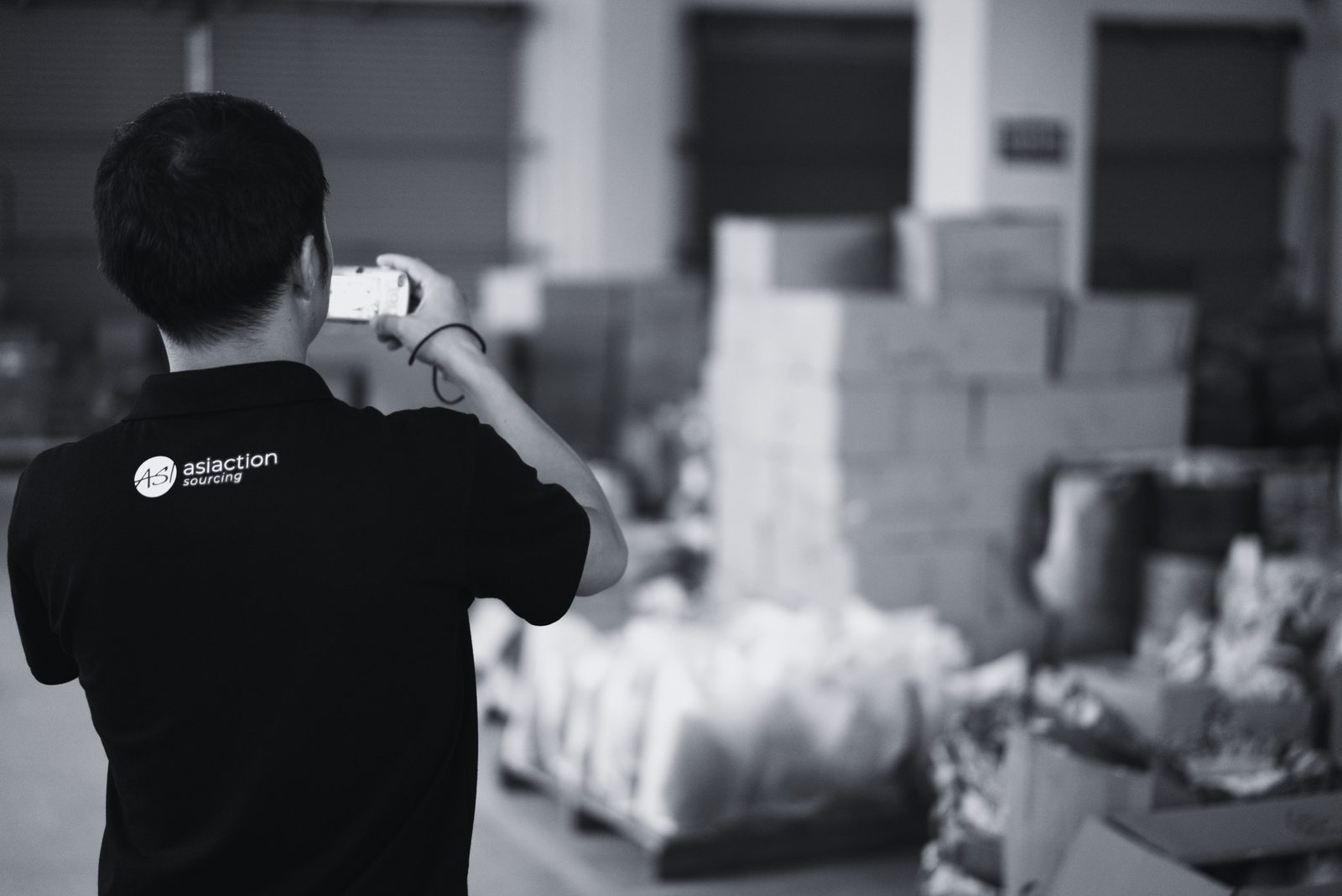 Asiaction team member checking and photographing toy cartons in a warehouse in China before shipment