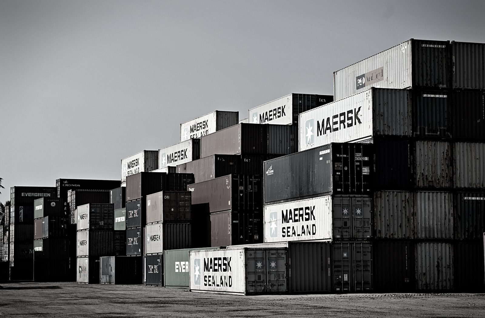 Stacked shipping containers waiting at a port terminal, where an imported container can be held by customs